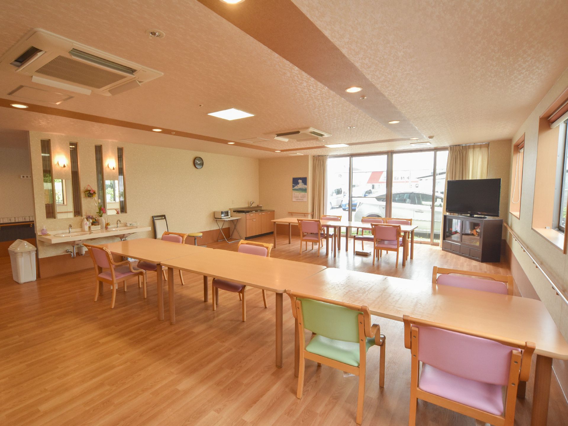 ダイニングルームには入居者がくつろげるように、大型のテレビを設置している。また天井には埋込み型のエアコンを完備している。