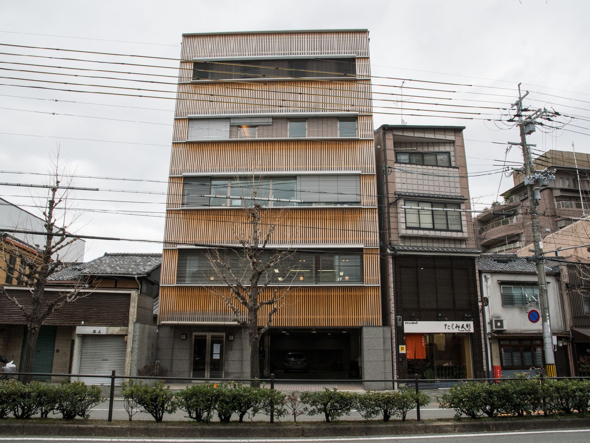 こちらは5階建てになっていて1階は駐車スペースとなっている。窓も横に広く取られている。外観は木になっている。