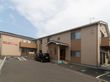 2階建ての建物で、入り口前に階段がある。施設前に駐車場が完備されている。茶系の外壁で落ち着いた雰囲気である。