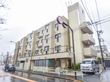 大通りに面した施設の外観。マンションのようなデザインの建物。