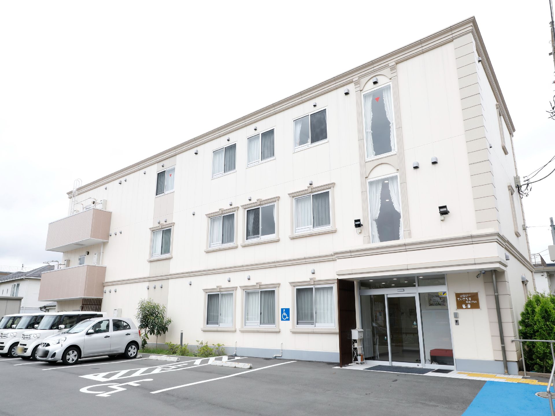 施設建物の前面にアスファルトで舗装された駐車場が完備している。玄関の右手に手すりがついていて、玄関まで掴まりながら歩行ができる。