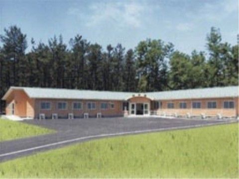 のどかな風景が広がる土地に施設がある。建物はＬ字形で中央部がエントランスになっており、開放感がある。
