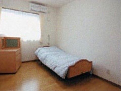木を使用した床や家具が設置された温かみのある居室である。窓の上部にエアコンがつけられており、室温調節ができる。