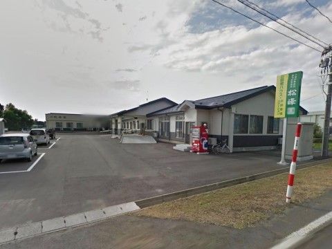 高齢者ハウス 松峰園の外観。のどかな場所に立地し、広い駐車スペースを完備している。