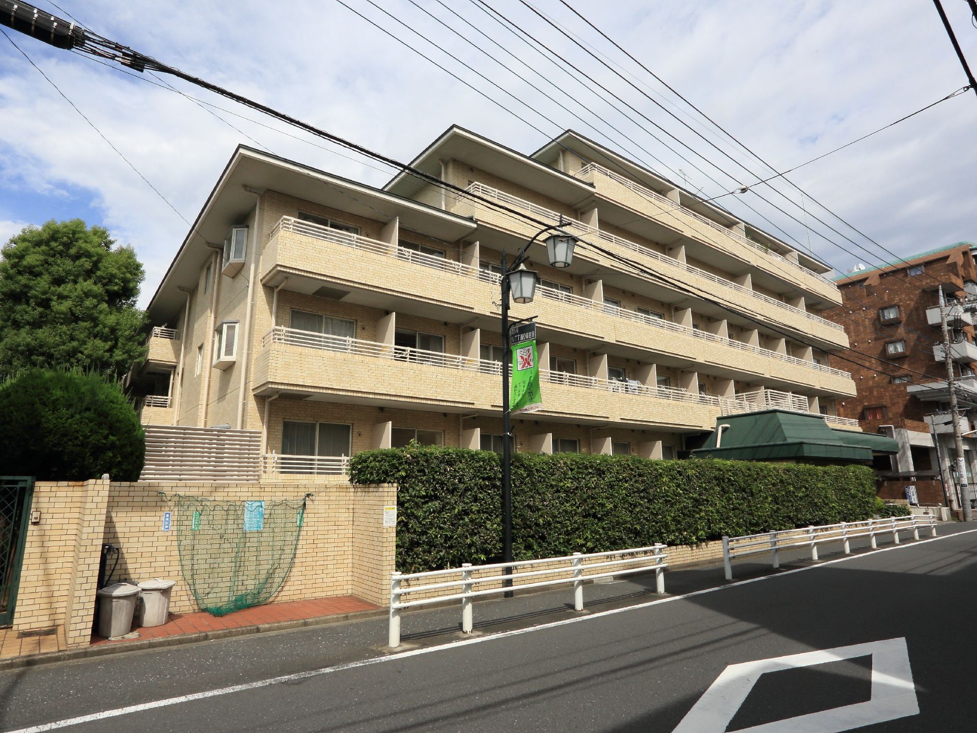 自動車通りに沿って建物が建てられている。ゴミは建物外の専用ゴミ置き場が設置されている。水道も取り付けられている。