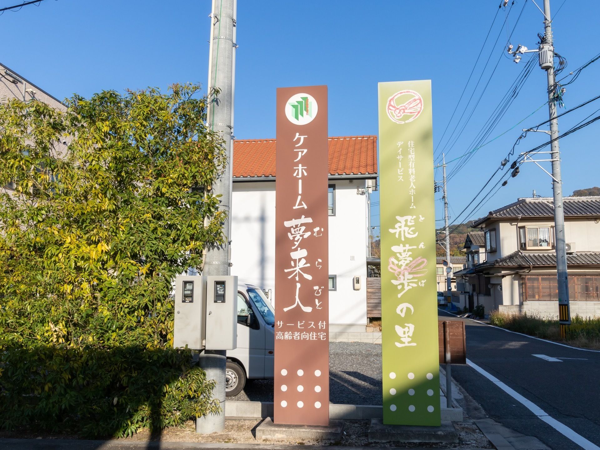 敷地の入り口には施設名を表した看板が設置されている。ブラウン色や薄い緑色の地に、白色の文字で施設名が書かれている。