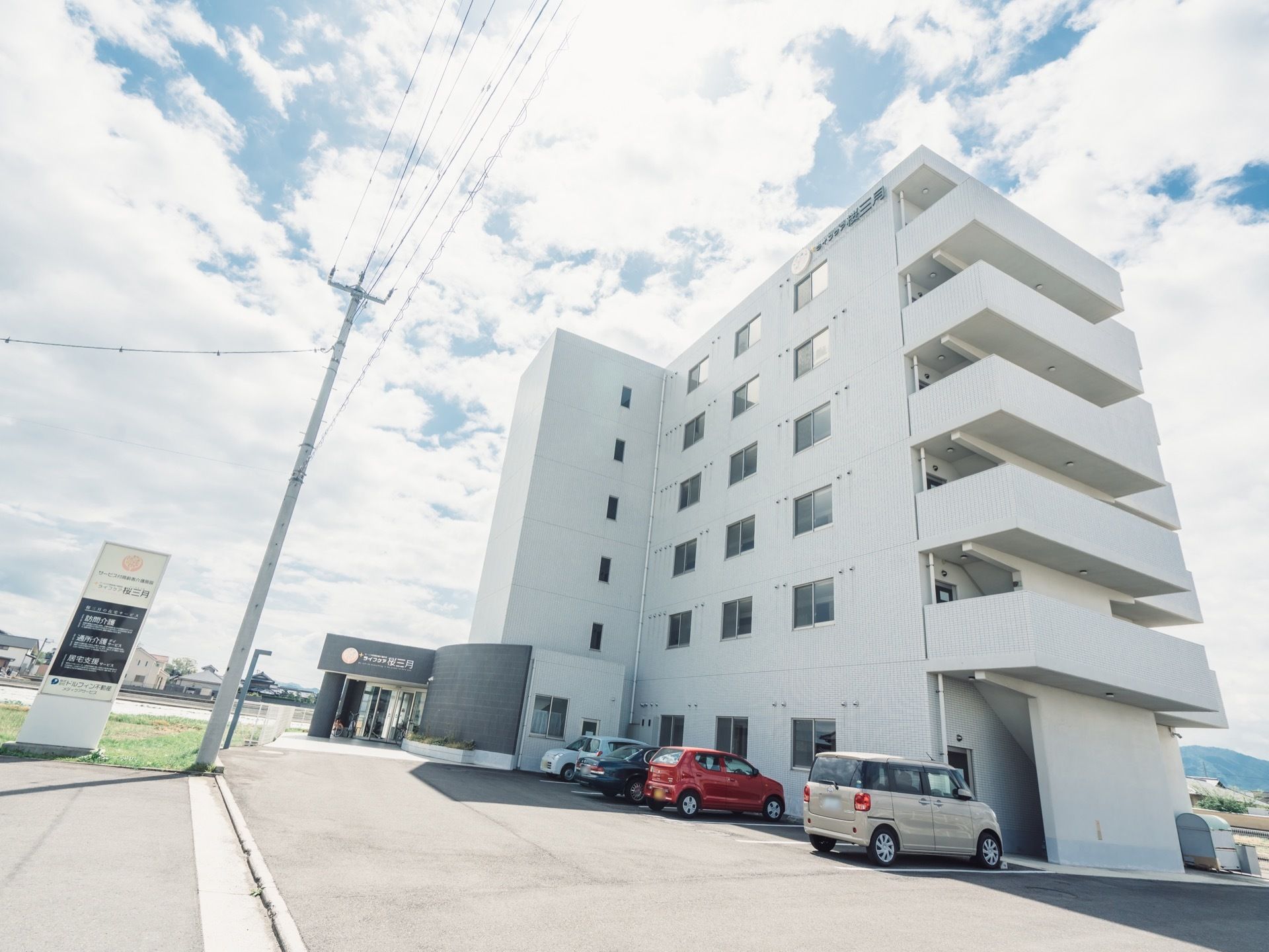 施設は大きな６階建ての建物で白色が基調となっている。駐車スペースを備えており、ご家族が来訪する際も安心して停めることができる。