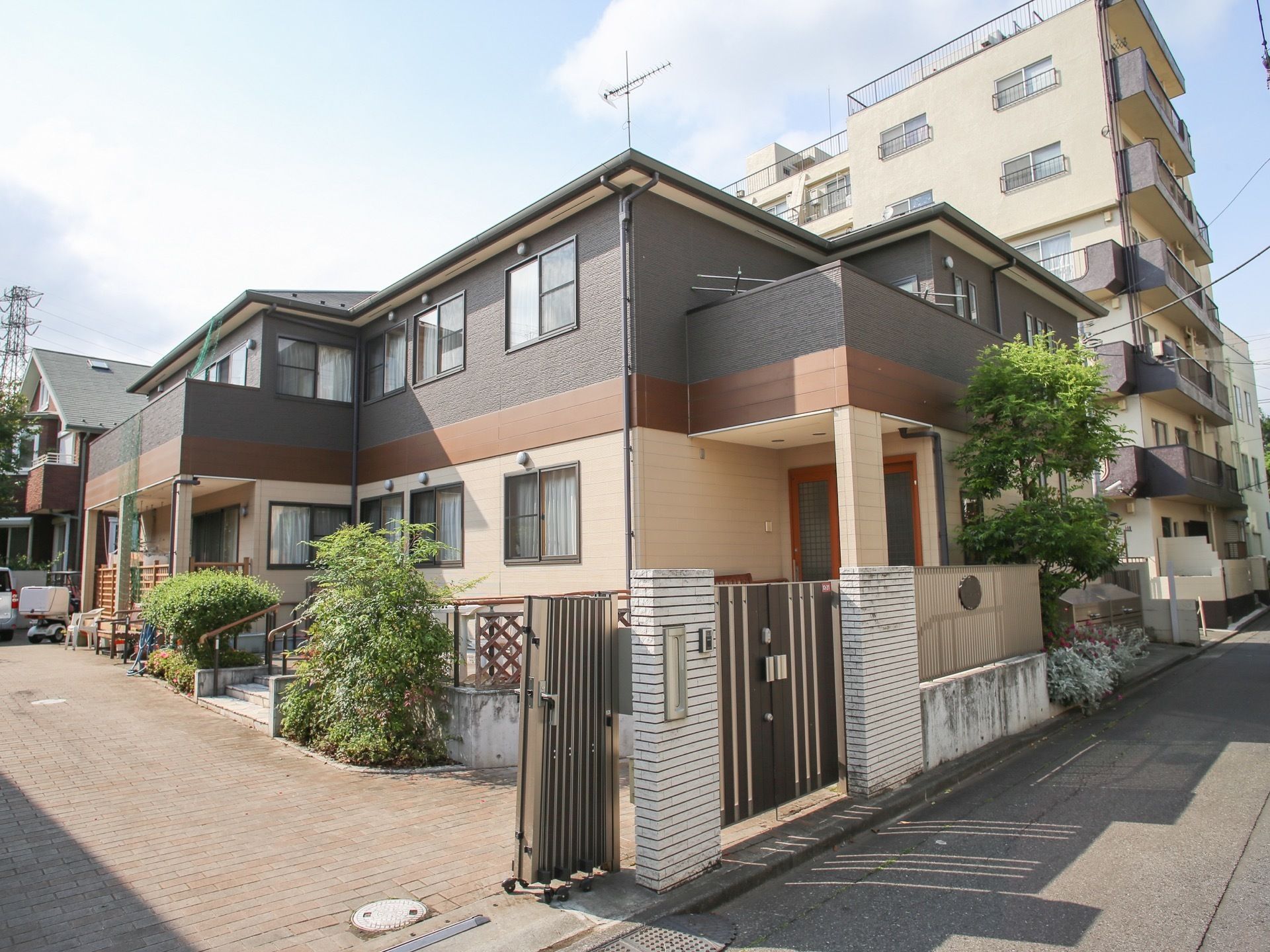２階建ての施設は、一般住宅のような外観になっている。玄関近くには植え込みがあり、奥にはテラスが見える。