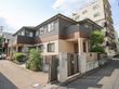 ２階建ての施設は、一般住宅のような外観になっている。玄関近くには植え込みがあり、奥にはテラスが見える。