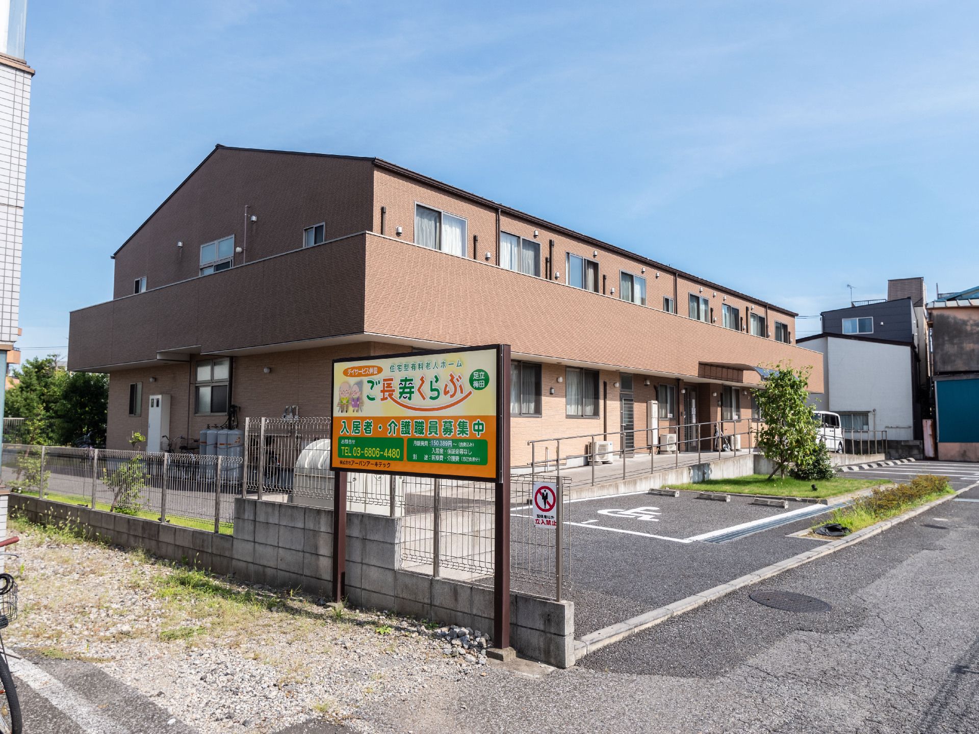アスファルトに隣接した2階建てでベージュの外観の建物
