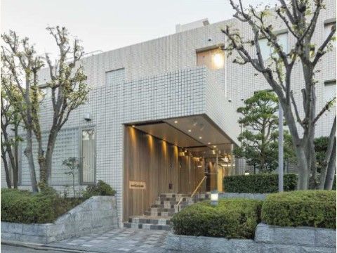 施設の入り口へと続く階段がある。階段の頭上は、大きなひさしのようになっている。天井に一列に埋め込まれたライトが下を照らしている。