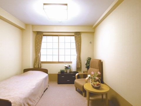 正面にある窓が障子のような格子状になっている部屋。大きなリクライニングチェアや観葉植物など、落ち着いた雰囲気が漂っている。