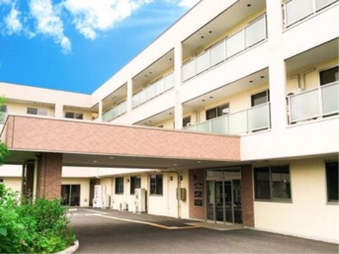 L字型の３階建ての白い建物。玄関ポーチのひさしは大きく、雨の日の外出も、車の乗り降りの際に濡れずに済む。