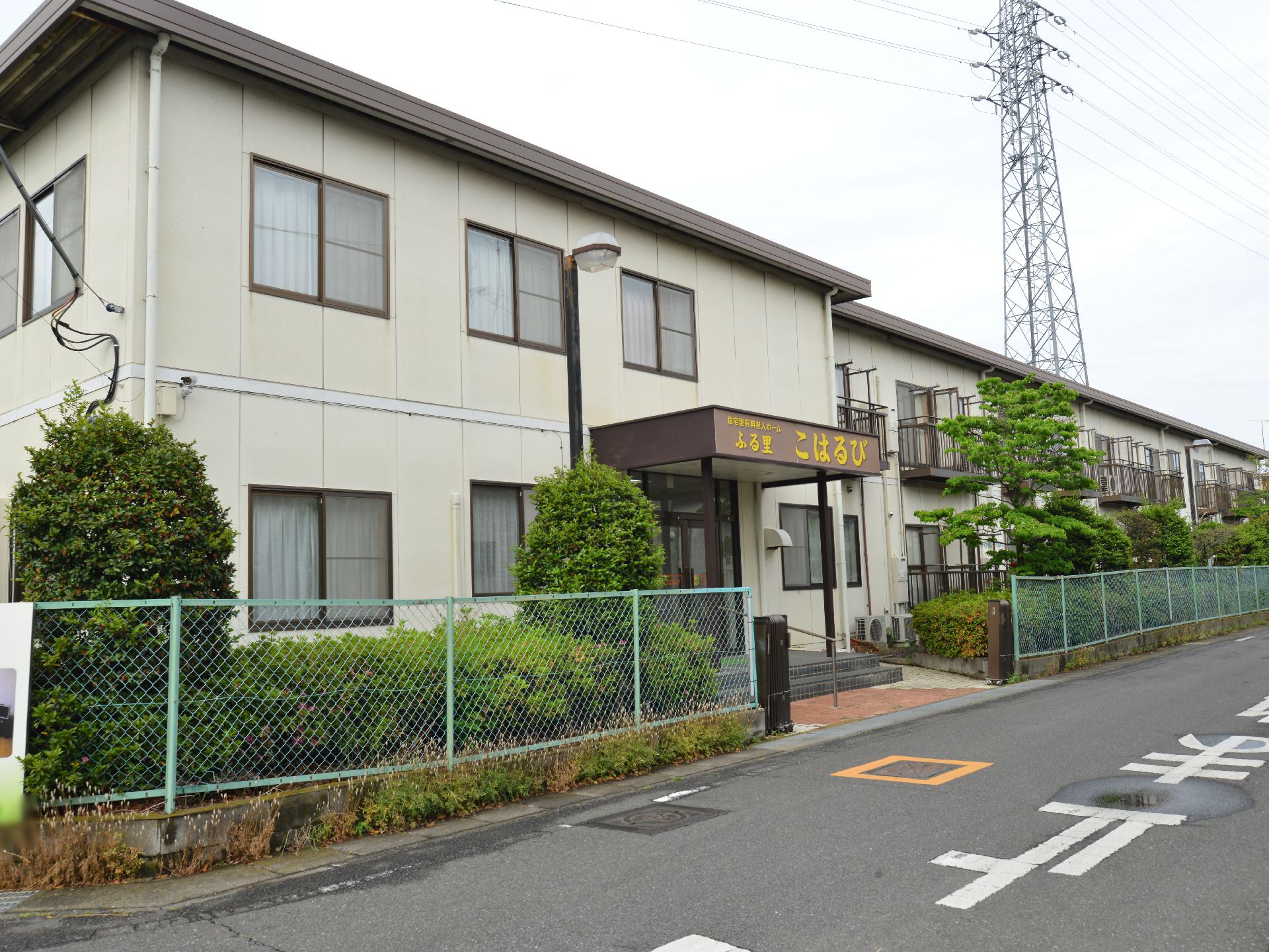 住宅地の中にあるシンプルな建物は、居室が横に並んだ二階建ての造りになっている。各部屋にベランダがある。