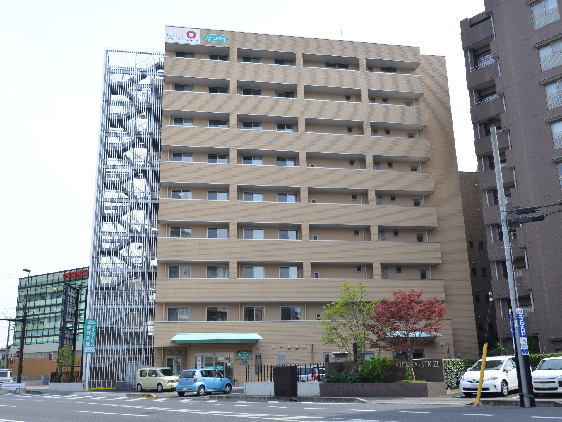 茶色の壁の大きなビルとなっており、下には駐車場も存在する。一階部分には、緑色の屋根も設置されている。