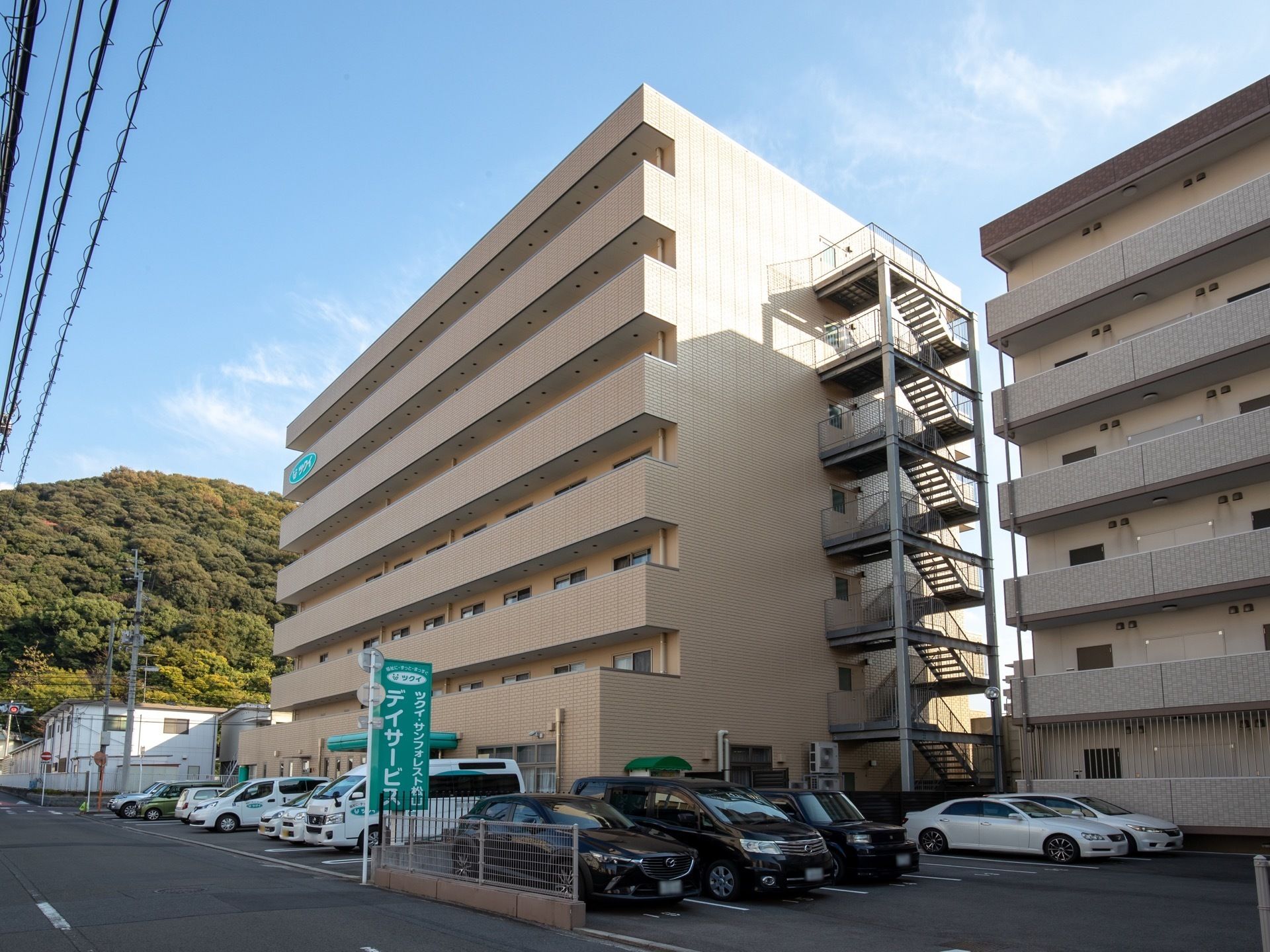施設は8階建てで、外壁が白色で統一された外観となっている。右側には、最上階まで屋外階段が設置されている。