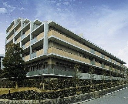 施設は、茶色い外壁で統一された大きな建物となっている。建物の周りは、大きな木やたくさんの植物で囲われている。