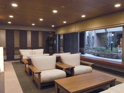 ロビーは、茶色や黒色を基調とした落ち着いた色味の内装となっている。中央には、白いソファーとテーブルが並べられている。