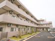 3階建の建物で、駐車場と駐輪場が付いている。駐車場と建物の間には植物が植えられている。消火栓が設置されている。