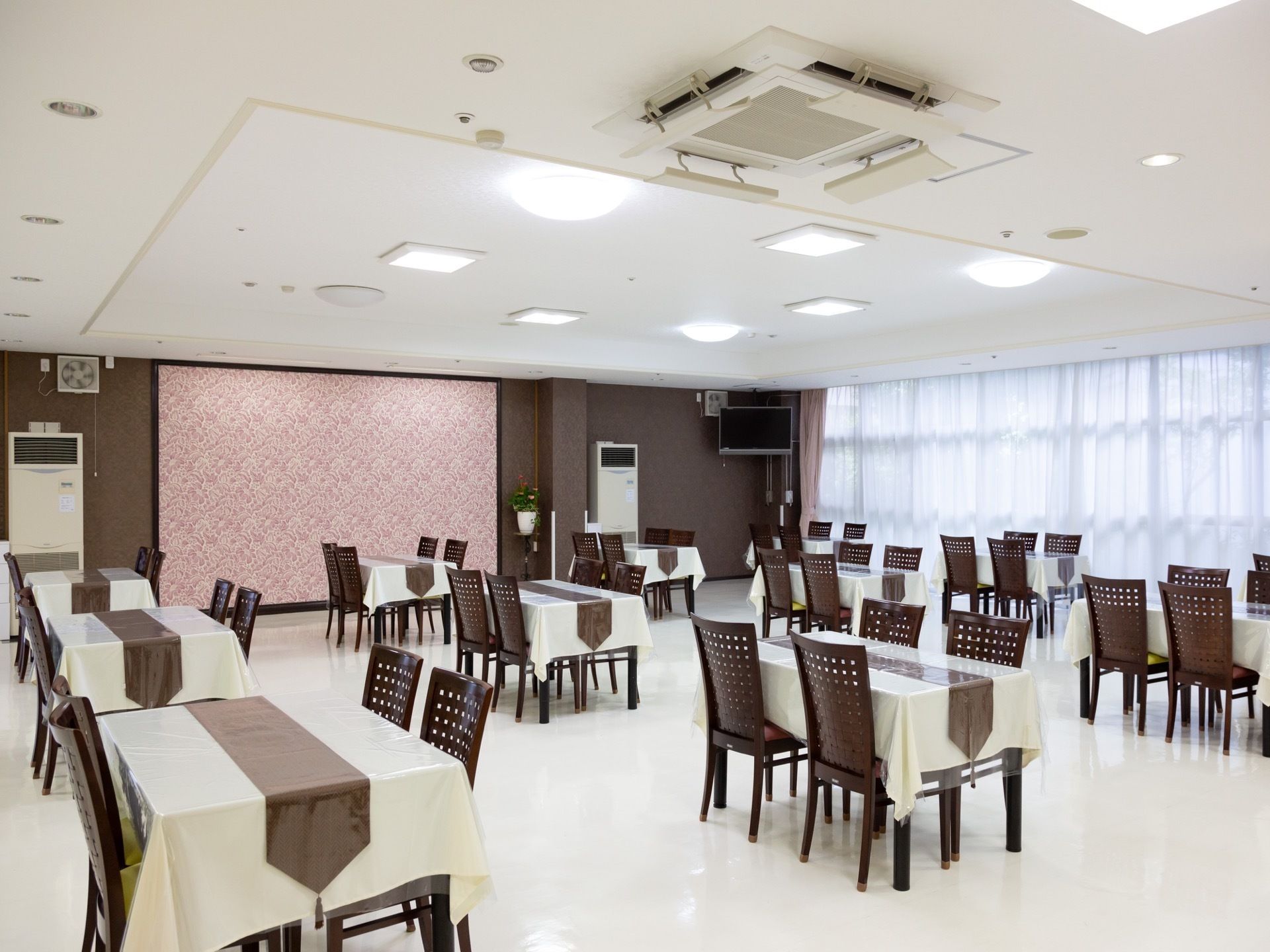 広々とした空間に等間隔でテーブルが配置されている。おしゃれな内装でレストランのような高級さが感じられる。