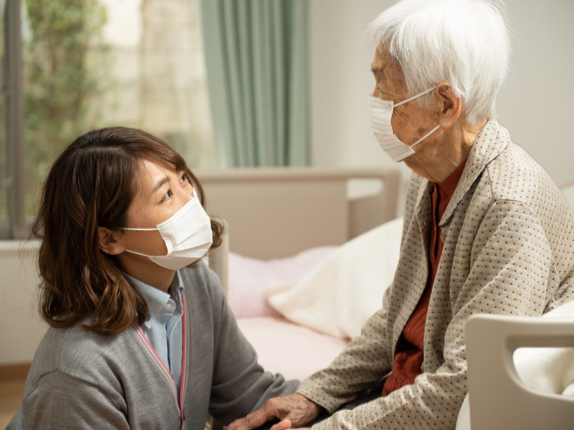フローリングの広々とした共有スペースには、淡い茶色のテーブルが並べられ、椅子が備わっている。室内には大きな窓がある。