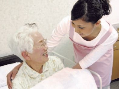 ご入居者様の顔色を見て、健康状態を確認するスタッフ
