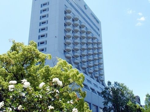 ビジネスホテルのようなスタイリッシュな外観。建物の周囲には木を植え、さりげなく１階部分のプライバシーを保護している。
