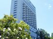 ビジネスホテルのようなスタイリッシュな外観。建物の周囲には木を植え、さりげなく１階部分のプライバシーを保護している。