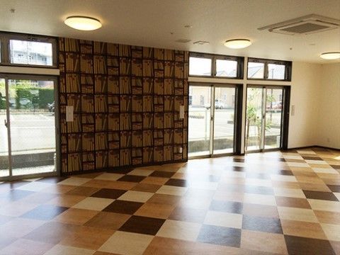 床は濃淡のある木目調で、壁の一部も同系色でデザインされている。掃き出し窓が何枚も付いていて明るいスペースである。