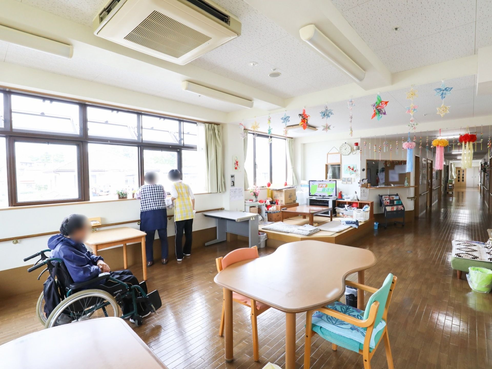 広々としたリビングダイニングには、食堂テーブルと椅子の他机やソファも置いてある。和室コーナーには、和風のテーブルとテレビが設置されている。