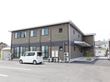 木造二階建ての施設には、18名住むことができる。玄関には階段とスロープの両方が設置されている。駐車場も完備。