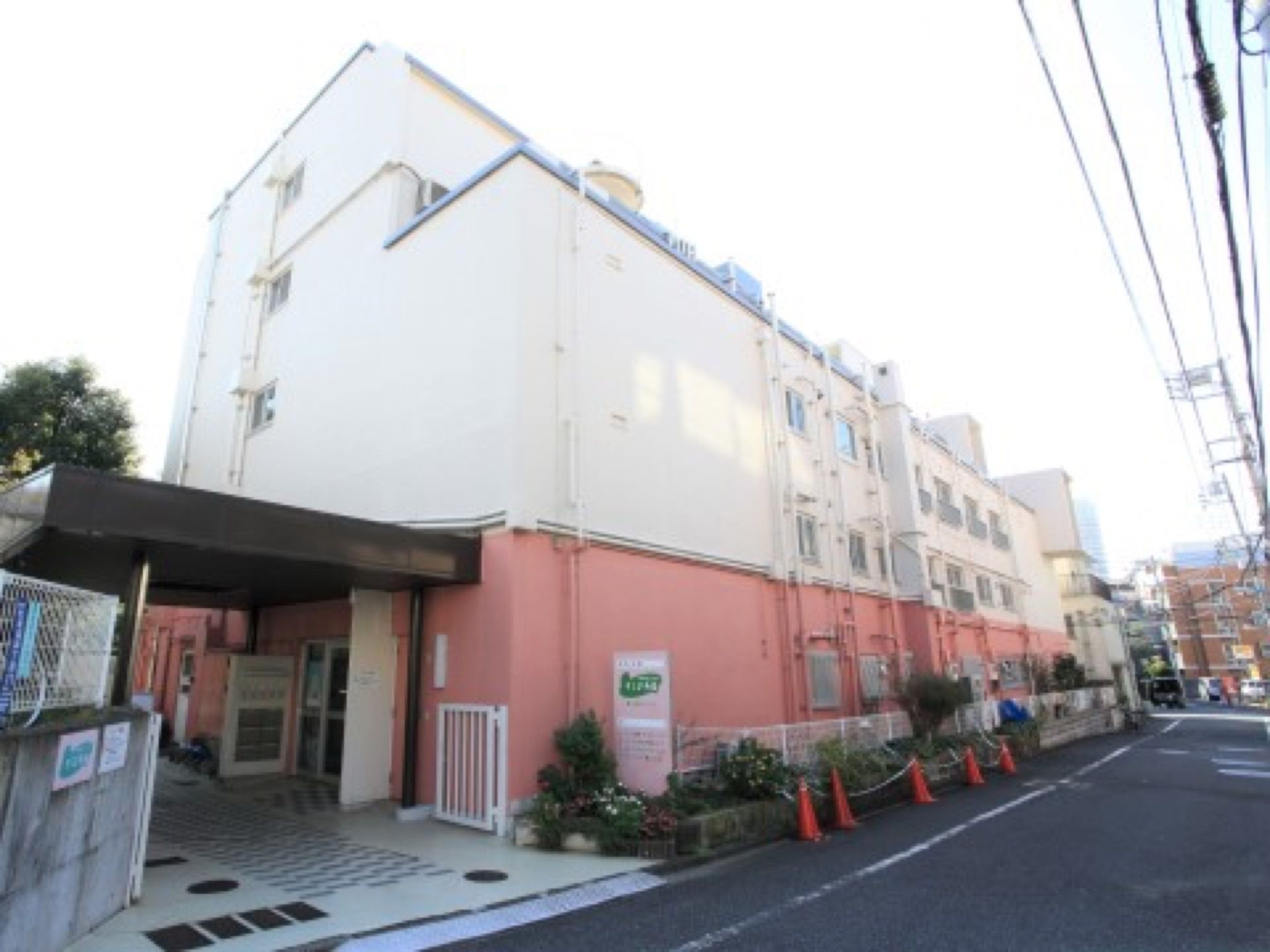 道路に面しており、横幅のある一部４階建ての施設である。一階部分の壁はピンク色に塗られている。玄関には大きなひさしがある。