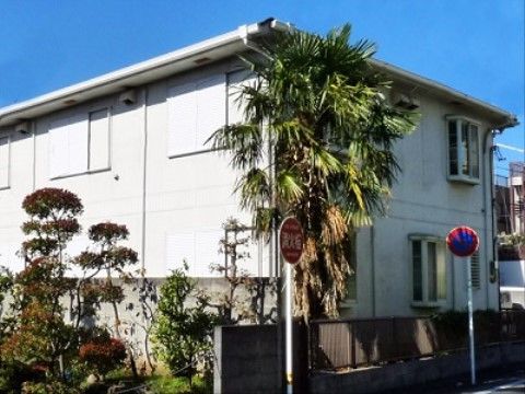 白を基調とした２階建ての外観は、シンプルで清潔感に溢れている。周辺は緑豊かな環境で、のんびりとお過ごしいただける。