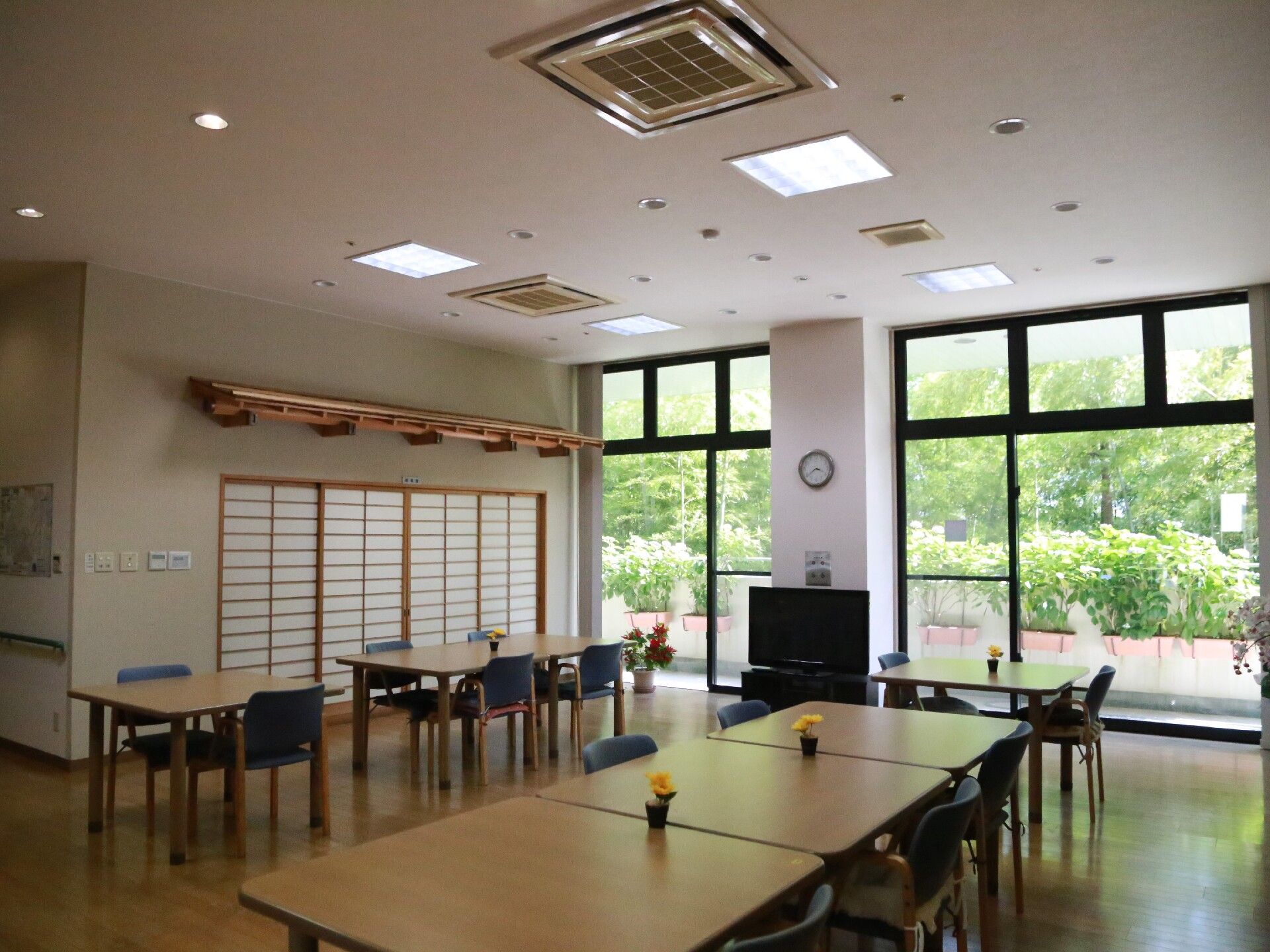 入居者様と一緒に出かけた初詣の様子。神社の社殿にはしめ縄が巻かれ、お正月の雰囲気。初詣を待つ人たちの列ができている。