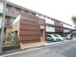 施設建物を外から見たところ。見るからに規模は大きく、道路に接する部分の壁には茶色い格子状のパーツが貼られている。