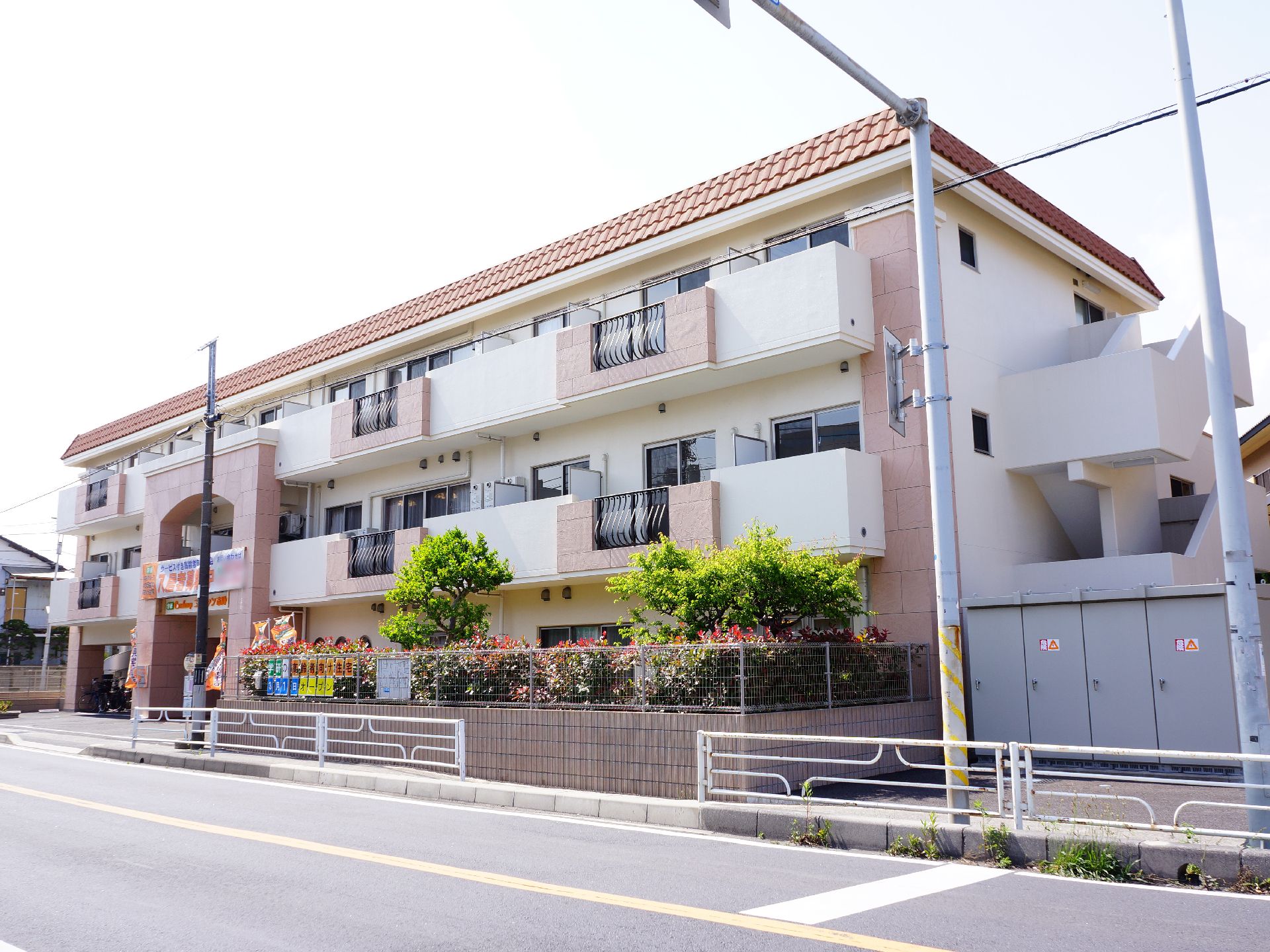 3階建ての施設はマンションのような外観で、道路に面した向きに個室の窓があり、ベランダが設けられている。