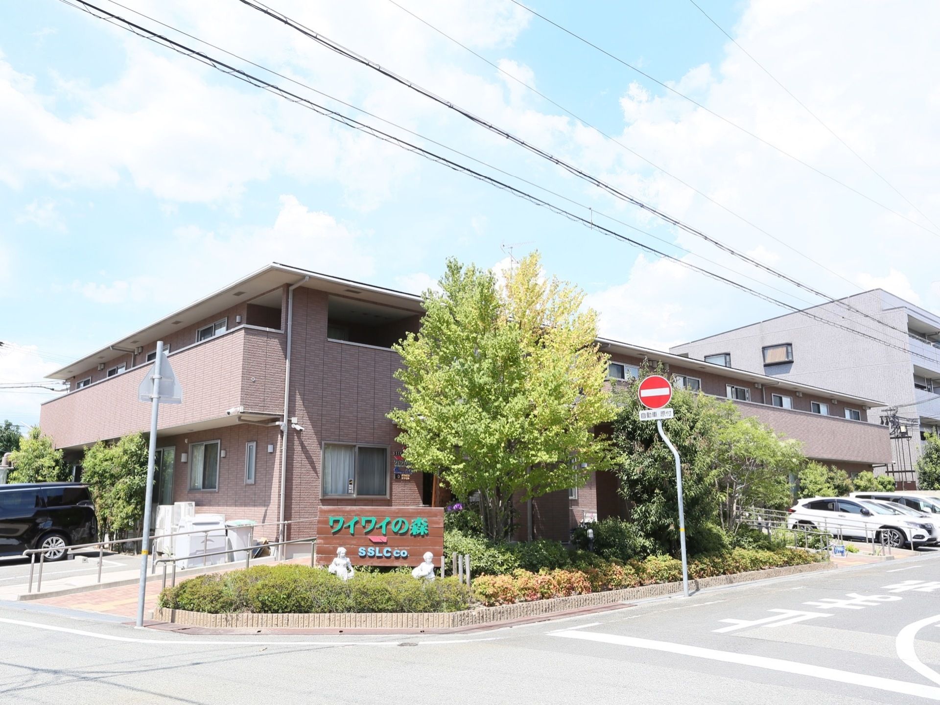 施設の周りには木々があり、ゆったりと過ごすことができる静かな環境である。玄関までは手すりのついたスロープを設置している。