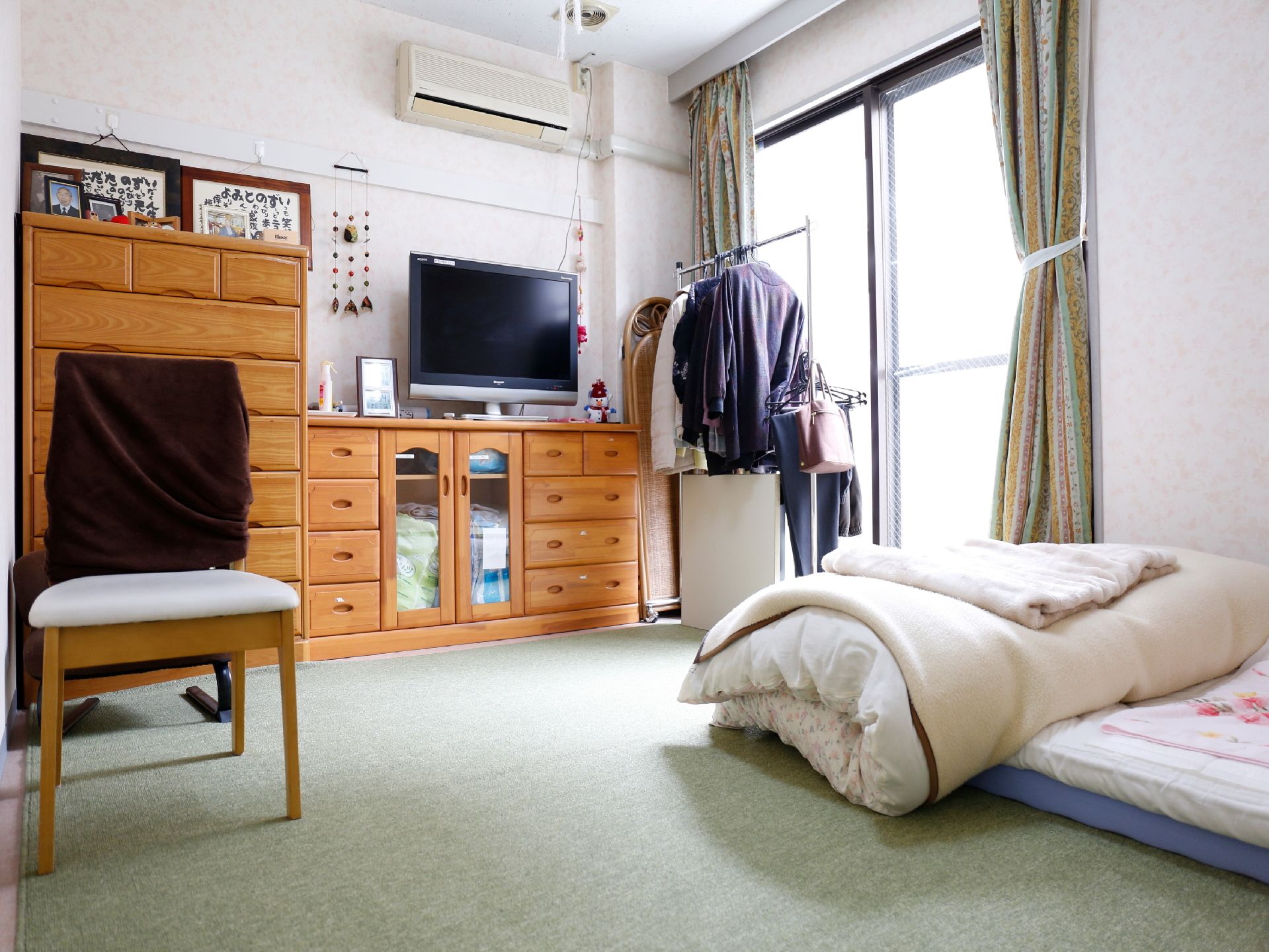 カーペット敷きの個室にはたんすが並べられ、布団が敷かれています。本当のご自身の家のように過ごしていただける。
