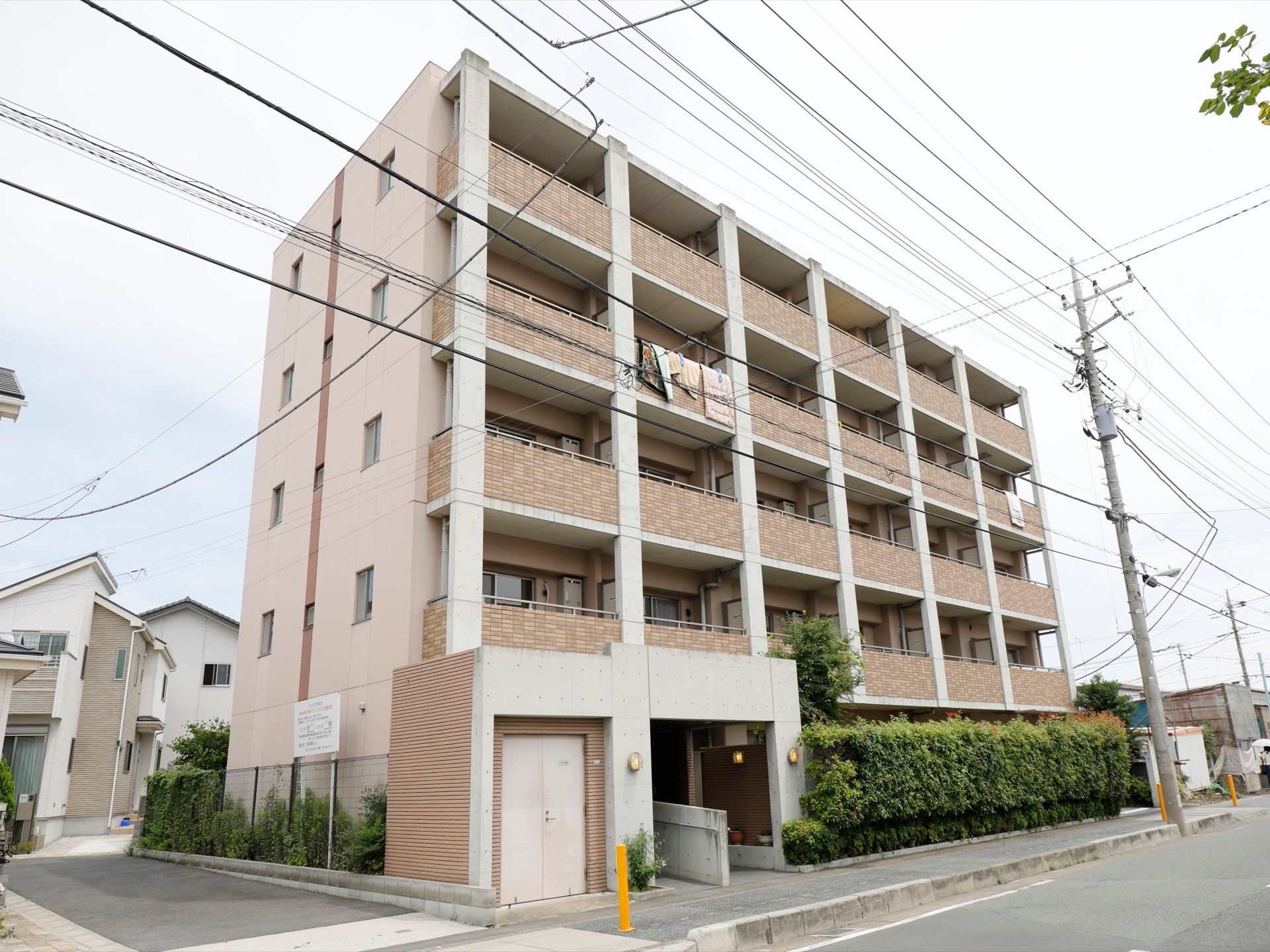 ブラウンを基調とした５階建ての建物である。建物の前には綺麗に手入れをした生垣があり、１階部分の目隠しにもなっている。
