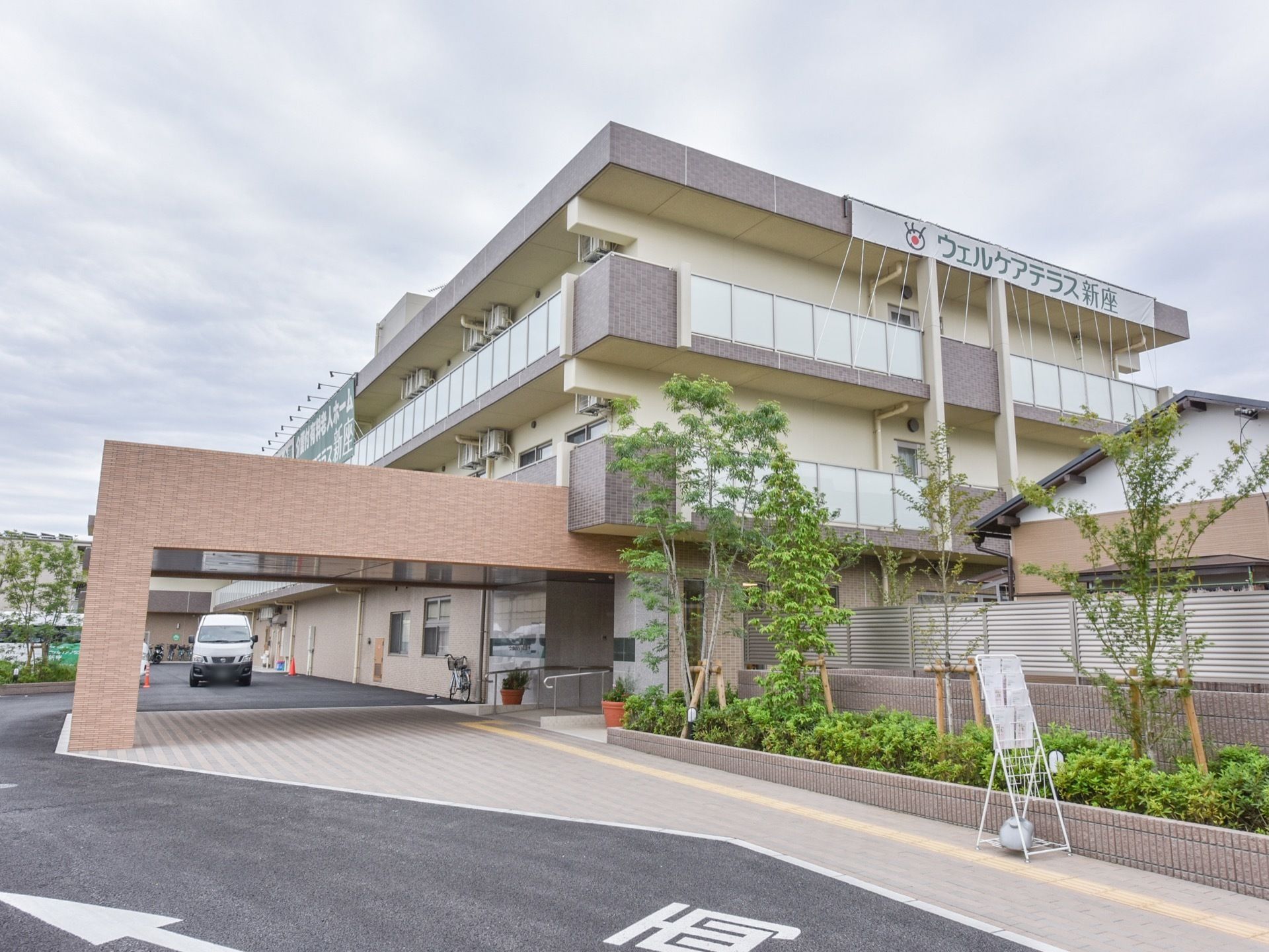 施設外観の屋上部分には、施設名の書かれた横に長いのぼりが掛けられており、いくつかのヒモによって支えられている。