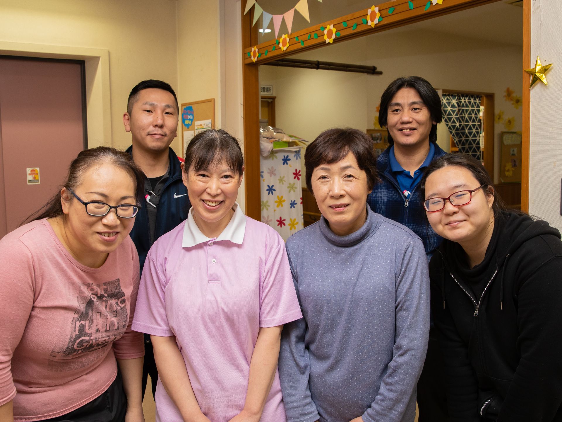 ６人の介護スタッフが写っている。入居者様は介護や看護にとどまらず、明るいスタッフと共に楽しい日常を過ごすことができる。