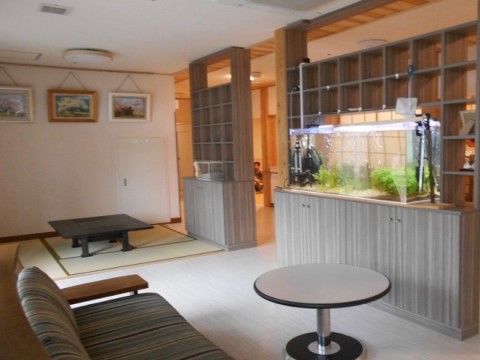 談話室は畳スペースが設けられていてくつろげる雰囲気である。ソファやテーブル、収納など落ち着いたインテリアでまとめられている。