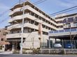 鉄筋コンクリートの５階建。最上階に施設名の看板あり。歩道から近い場所にも看板を設け目印となっている。