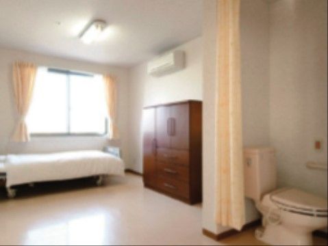 窓からやわらかな日差しが差し込む明るい居室である。トイレの仕切りがカーテンになっているので移動もスムーズである。