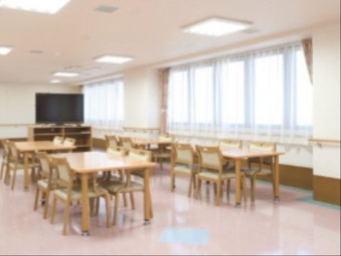 明るく広い室内で、テーブスと椅子が多数配置されている。室内壁面と、大きな窓の下には手すりが設置されている。