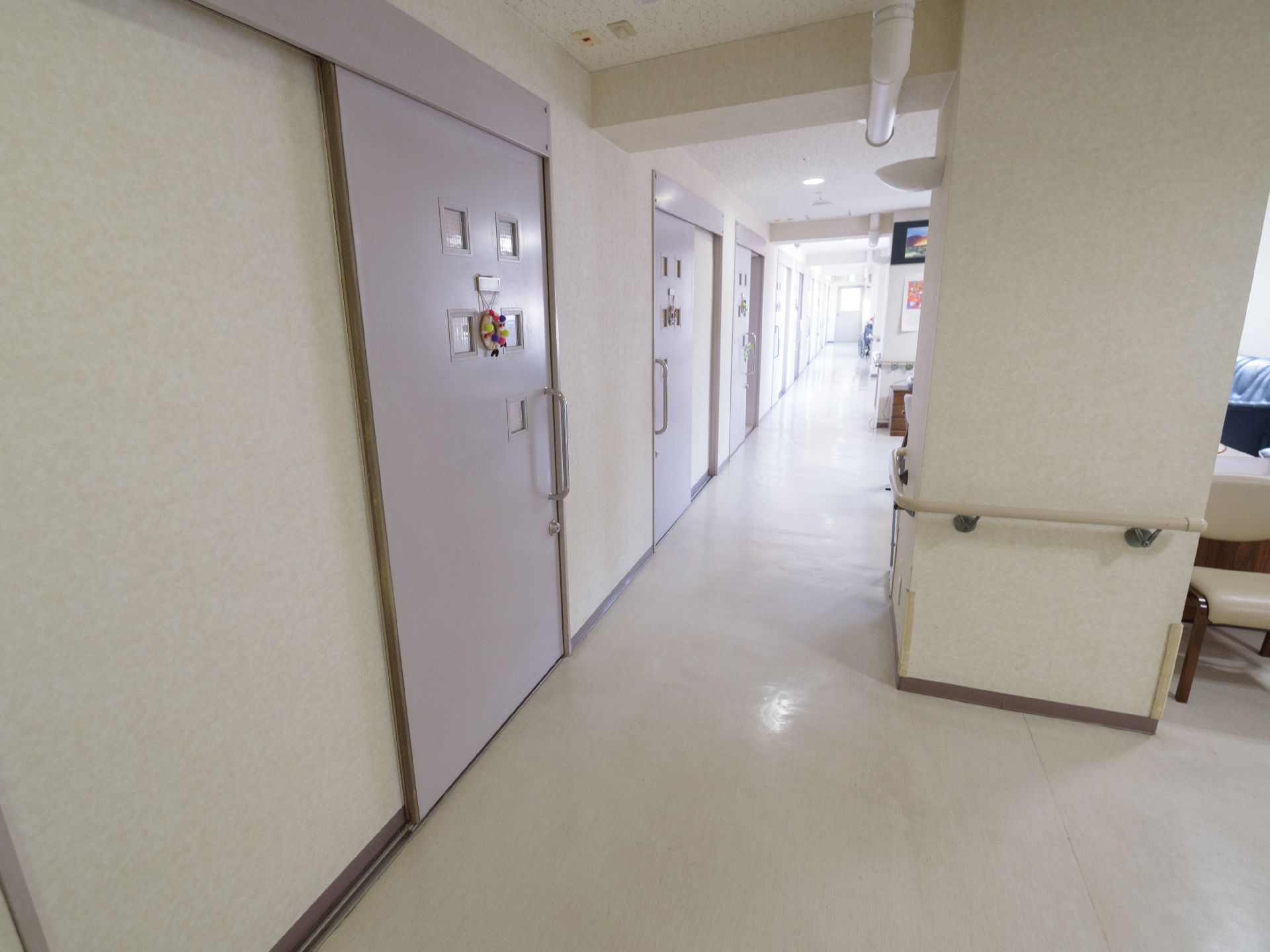 手すりが柱に取りつけられている。個室のドアに、小物が飾られている。明るく広々としており、清掃が行き届いている。