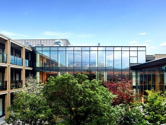 ガラス張りの壁が特徴的な大きな建物である。敷地には多くの木々が植えられており、自然に親しむことができる環境である。
