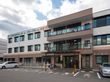 白とブラウンで統一された３階建ての大きな建物である。エントランスの前には駐車スペースがあり広々としている。