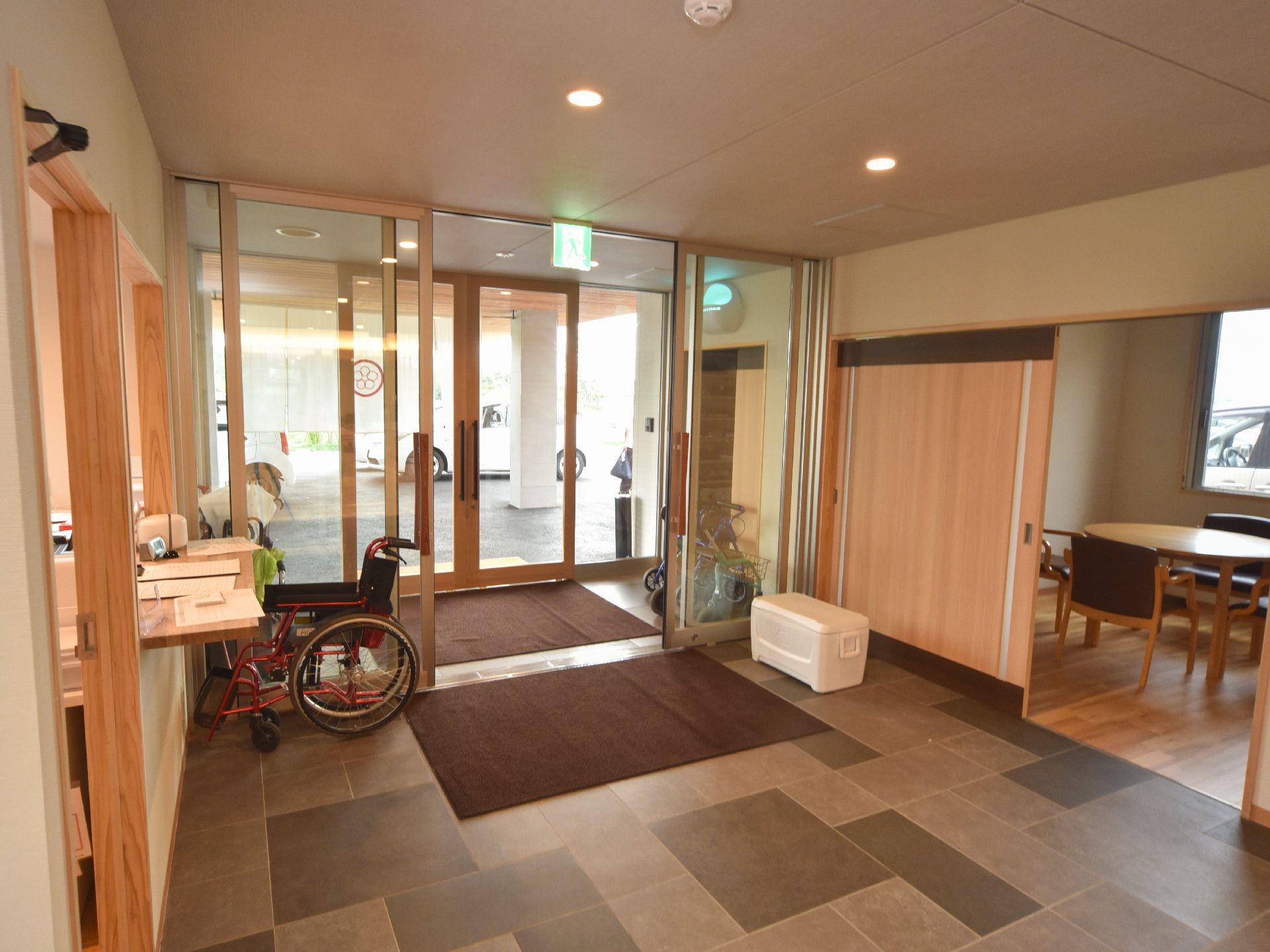 エントランスホールには、風除室があり歩行補助具などが置かれている。また玄関の扉は両側に大きく開く自動ドアとなっている。