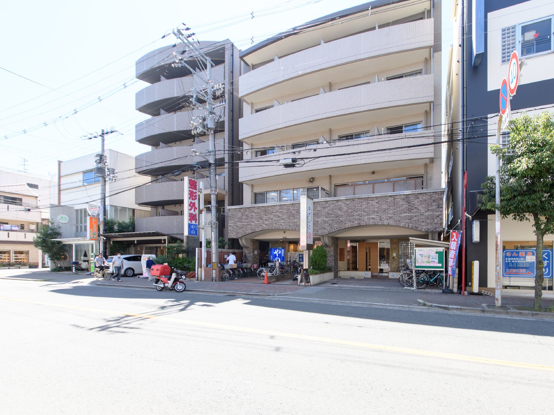 建物の一階の左側に整形外科があり、右側が施設の入り口である。両隣にも同じくらいの高さの建物が建っている。